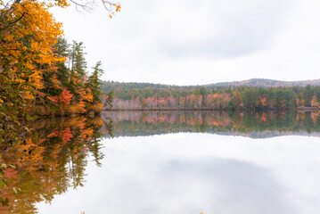Lake mirroring fall foliage colors in the morning