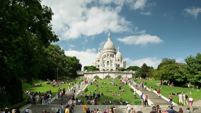 sacre coeur cathedral in paris with tourists on the steps