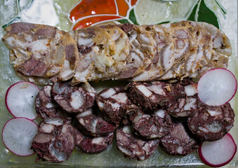 Pork Charcuterie: Sliced Head Cheese and Blood Sausage on Glass Tray with Radish Garnish
