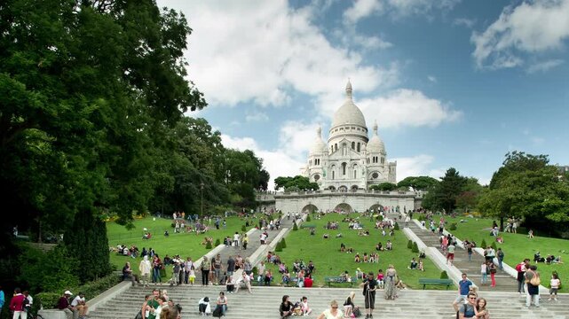 sacre coeur cathedral in paris with tourists on the steps