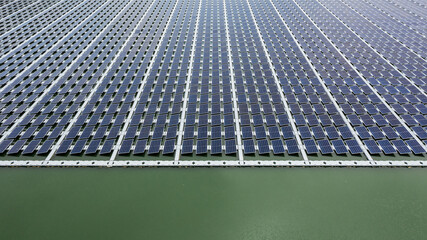 Aerial view of floating solar panels on a river, part of a hydroelectric power plant using renewable energy for industrial electricity.