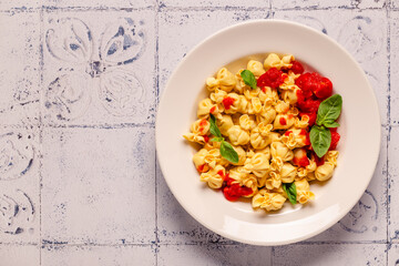 Sacсhettini pasta in a plate with tomato sauce.