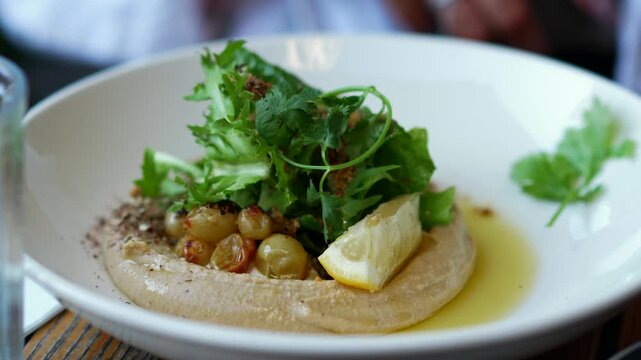 hummus in a plate.
National food.
Cilantro leaves in a plate.
Delicious food