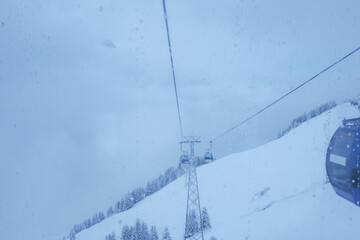 The cable cars is riding on the robe way with snowy moutain and blue sky background. Near...