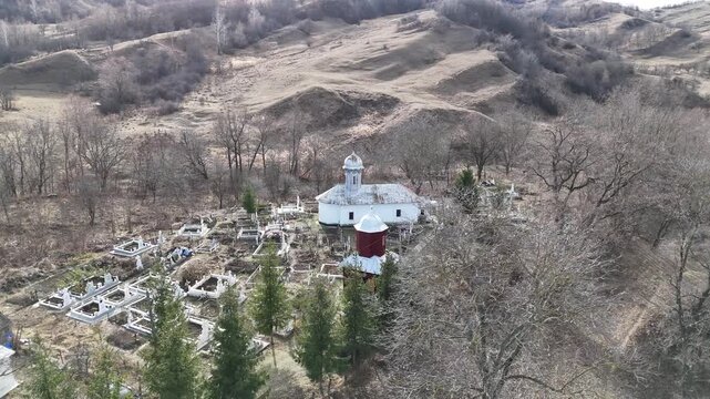 Landscape of an ld village in the mountains with church and cemetery,  Goicel, Buzau, Romania
