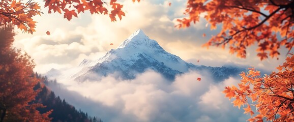 Autumn leaves frame a snow-capped mountain peak peeking through clouds.