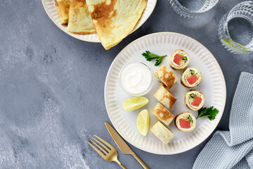 Homemade crepe rolls stuffed with salted salmon, cream cheese and fresh cucumber. Delicious appetizer. top view