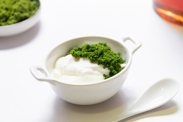 Greek yogurt and wolffia globosa in ceramic bowl isolated on white table background. Wolffia is the nutrient-rich plant-based source of protein and omega3 and vital minerals. Healthy and easy meal.