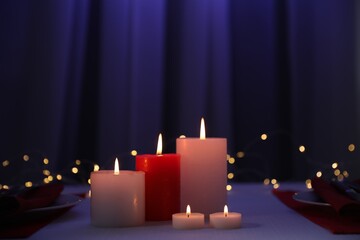 Burning candles on table indoors. Bokeh effect