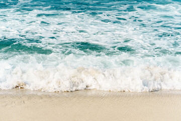 Sea waves with white foam on the shoreline