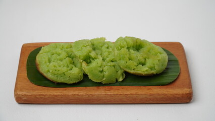 Cara bika or carabikang cake, traditional Indonesian cake on a wooden plate isolated on a white background
