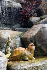 decor in the form of turtle against the backdrop of an artificial waterfall