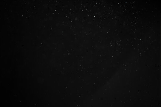 abstract real dust floating over black background for overlay
