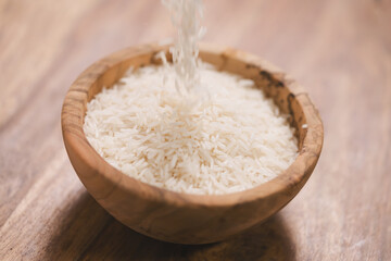 falling dry rice into wood bowl