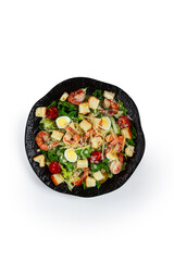 caesar salad with tiger prawns, shrimp salad, lettuce leaves, quail eggs, cherry tomatoes, parmesan cheese, on a black plate, isolate,