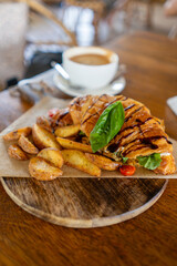 Enjoy a freshly baked croissant served with wedges and coffee on a charming rustic wooden table