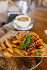 Savor a Croissant Sandwich, Potato Wedges and Coffee a delicious and filling meal