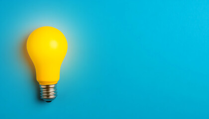Yellow light bulb glowing against a bright blue background, symbolizing ideas and innovation.
