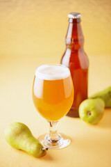 Boozy Refresing Cold Hard Pear Cider or Craft Fruit Beer in a Pint Glass on wooden table. Copy space