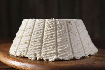 Tasty ricotta (cream cheese) on wooden table, closeup