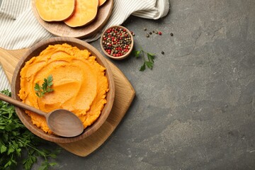 Delicious mashed sweet potatoes served on gray textured table, flat lay. Space for text