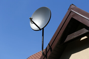 Tile roof antenna background. TV satelite dish old house roof. Countryside village architecture...