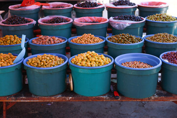 Buckets of colorful olives for sale in street food market.