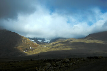 Play of light and shadow on Himalayan mountains beside road to Gurudongmar Lake, Sikkim, India. Considered sacred by Buddhists, Sikhs and Hindus. Named after Guru Padmasambhava, Guru Rinpoche.