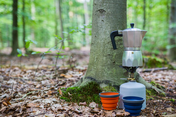 Fototapeta premium Picnic in the forest. Making coffee on a stump in the middle of a clearing.