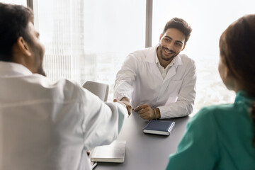 Two male doctors shake hands start council or seminar, finalizing decision, welcoming new member to team, concluding successful meeting, express mutual respect, camaraderie among medical professionals