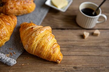 Croissant au petit déjeuner sur un plateau en bois.