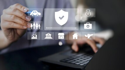 A businessman using laptop with insurance concept on visual screen for health, real estate, store, bank, family and transport icons.