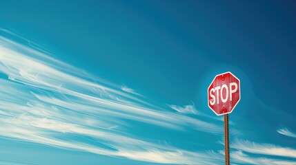 Long exposure shot of a still stop sign against the vivid blue sky