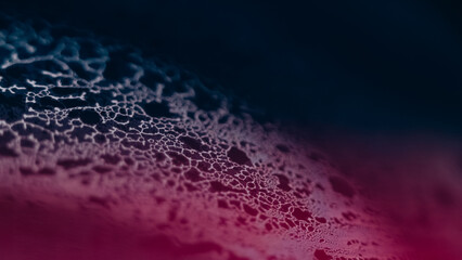 Blur foam flow. Bubble liquid. Defocused pink blue color fizzy texture fluid mix wave on dark black...