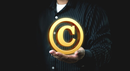 Businessman holds Copyright symbol or intellectual property rights of patentee. Business concept of author rights, designer, and trademark license.