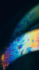 Oil paint mix. Gasoline fluid. Defocused pink orange blue color rainbow curve acrylic slick on dark black abstract art background.
