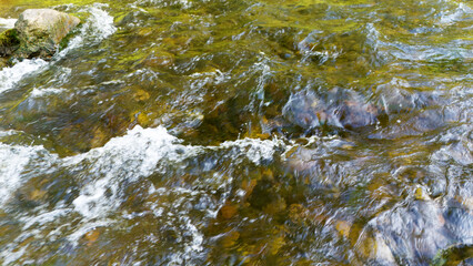 Zdjęcie płynącej wody i kamieni pod wodą w strumieniu, zasoby graficzne, tekstura, widok z góry. © Stanisław Błachowicz