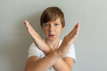Stop gesture. Little kid showing two hands cross arms say no X sign at studio shot isolated on...
