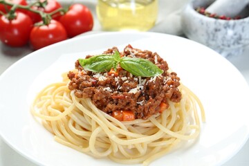 Delicious pasta bolognese with basil on table, closeup