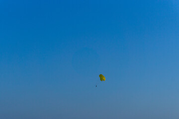 Parachutes flying in the distance over the blue sky