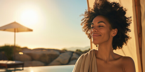 Attractive black woman in cabana at luxury desert resort spa pool with scenic sunset view