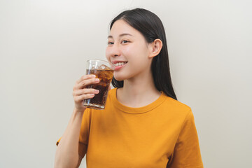 Smile happy thirsty asian young woman, girl drink or sip, holding glass of cold sparkling soda,...