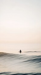 Fototapeta premium Surfer entering the calm ocean waves at dusk with a pastel sky