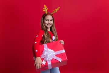 New Year sale. Teen girl hold holiday shopping gift from Santa Claus. Xmas present and gift. Teen girl isolated on red. Christmas shopping sale. Happy New Year 2024. Xmas holiday present