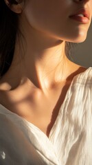 Soft sunlight illuminating the neck and shoulder of a woman in a light fabric top during sunset