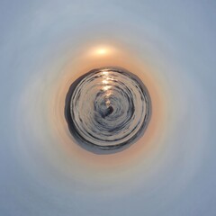 Aerial view of the sun rising through the hole in the sky