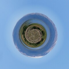 Little planet transformation of spherical panorama 360 degrees. Spherical abstract aerial view in field with trees. Curvature of space.