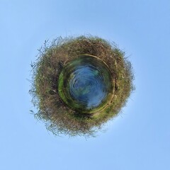 Little planet transformation of spherical panorama 360 degrees. Spherical abstract aerial view in field with grass. Curvature of space.