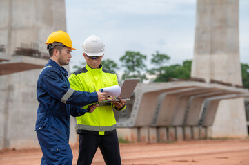 An Asian male engineer works at a motorway bridge construction site,Civil worker inspecting work on crossing construction,Supervisor working at high-speed railway construction site