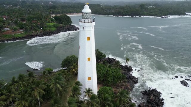 Aerial reveal shot of a lighthouse, capturing its ascent from the surrounding landscape to the iconic beacon above